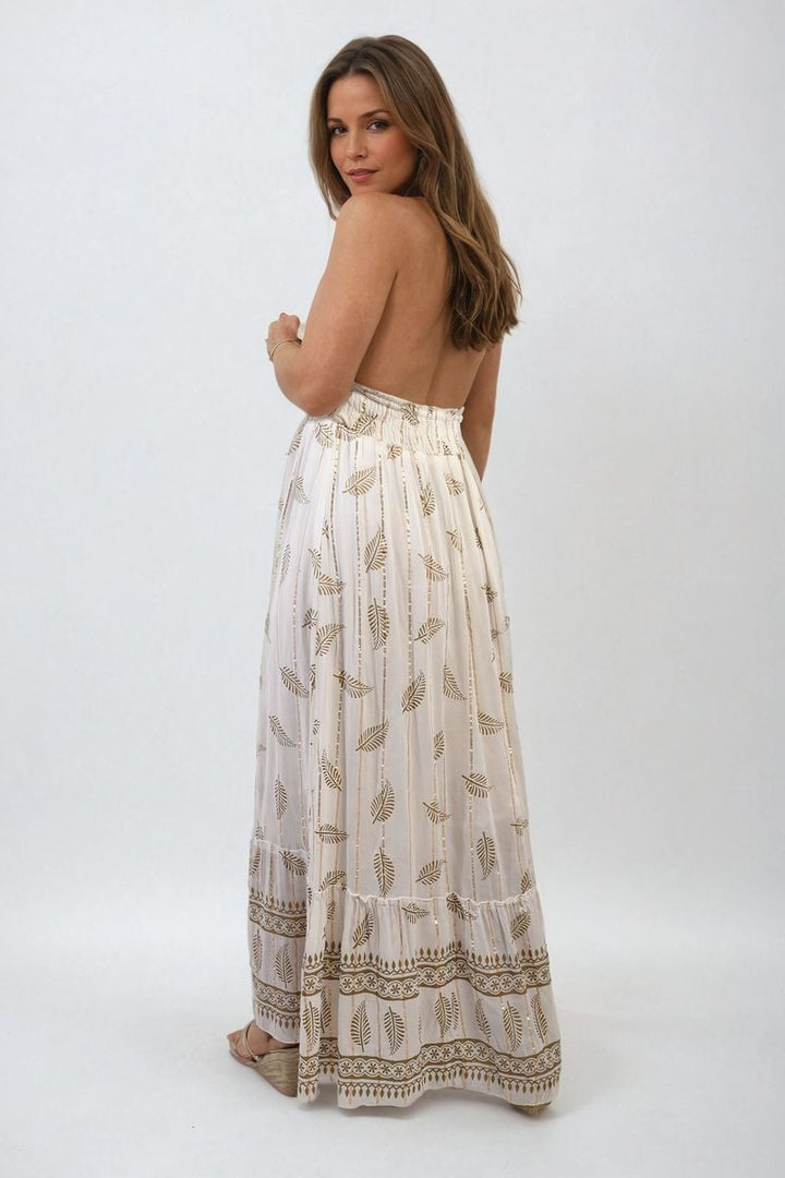 Woman wearing the Dazzling Leaf Print Spaghetti Strap Maxi Dress, showcasing its elegant leaf pattern and flowing design, ideal for summer occasions.