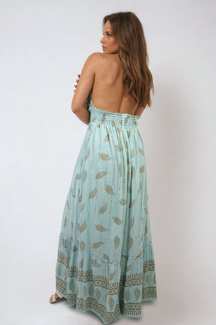 Woman wearing the Julia Dazzling Leaf Print Spaghetti Strap Maxi Dress, showcasing elegant leaf patterns and flowing design for stylish summer occasions from Holiday-clothes.co.uk.