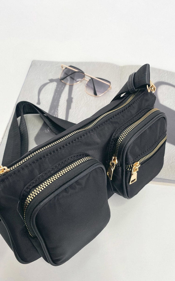 Julia Shoulder Handbag with gold zippers and sunglasses, featuring adjustable strap and outer pockets, ideal for stylish, practical everyday use.