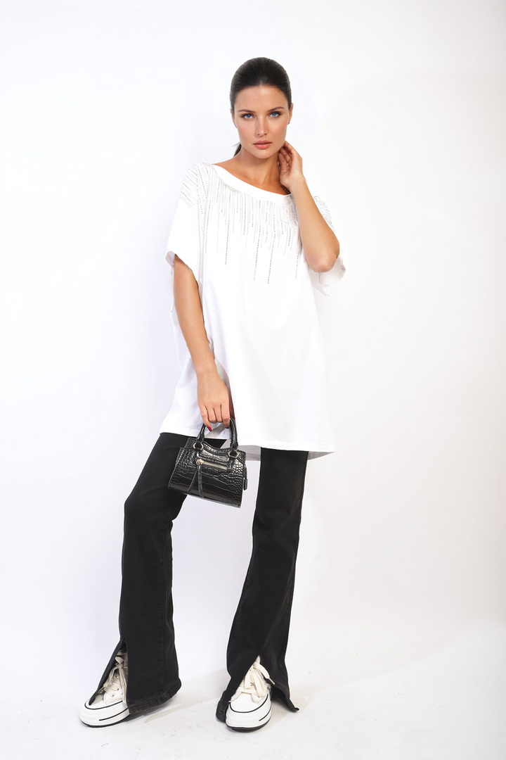 Woman in white Juliana Embellished Neckline Short Sleeve Top holding a black purse, showcasing the top’s chic, stylish design suitable for various occasions.