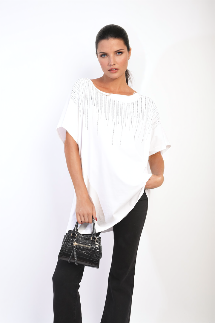 Woman in white Juliana Embellished Neckline Short Sleeve Top holding a black purse, showcasing the top's stylish design and chic neckline detail.