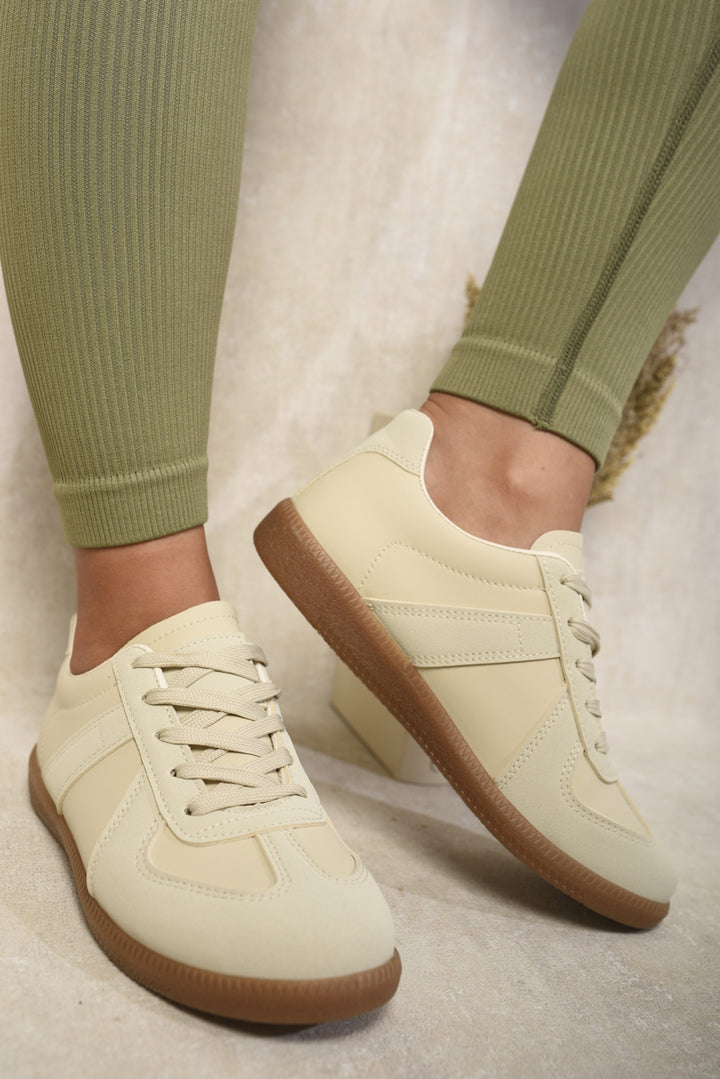 Low Top Lace-Up Trainers showcased on a person's feet, emphasizing their modern design and versatility for casual and everyday wear.