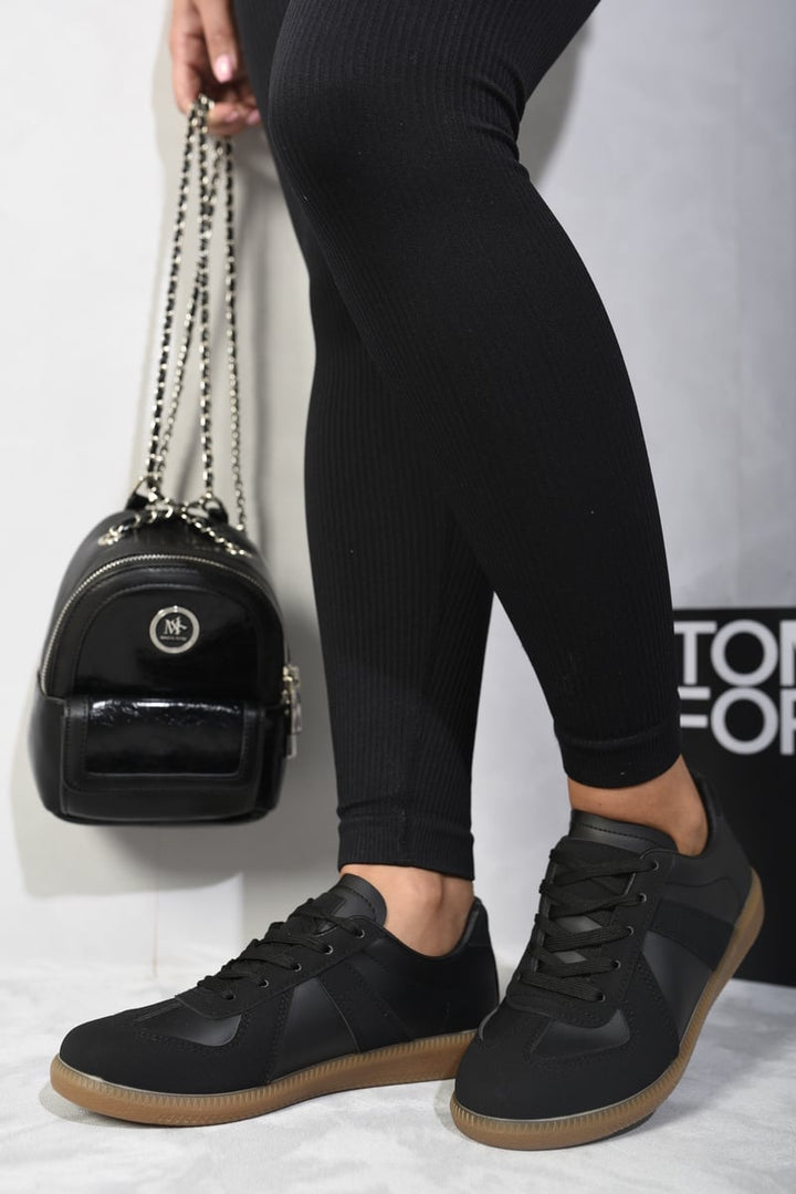 Black leggings paired with Julissa Low Top Lace-Up Trainers, highlighting the footwear's modern design and lace-up detail. Perfect for stylish, comfortable everyday wear.