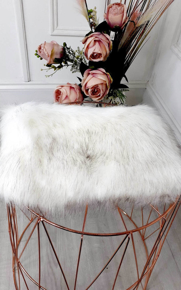 Faux Fur Shoulder Bag with silver chain strap, displayed on a metal frame, accompanied by a bouquet of pink roses.