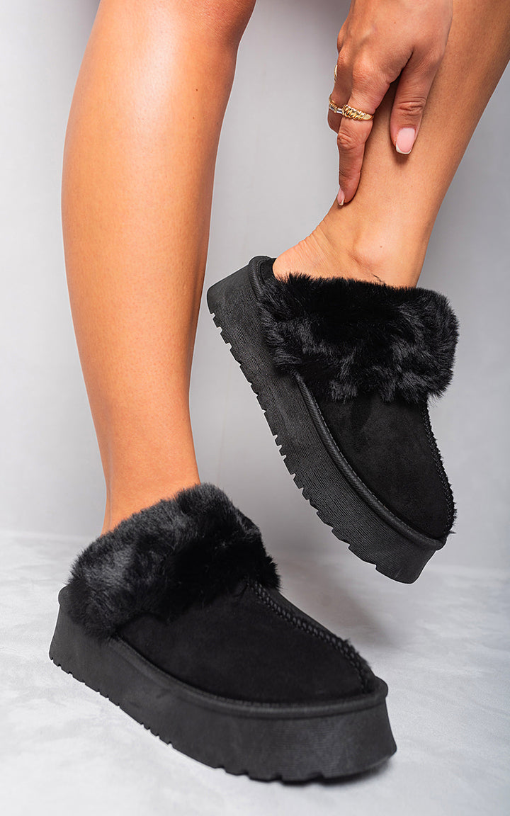 Person wearing Kelly Faux Fur Trim Whisp Chunky Platform Slippers, showcasing the stylish faux fur detail and chunky platform design for cozy elegance.