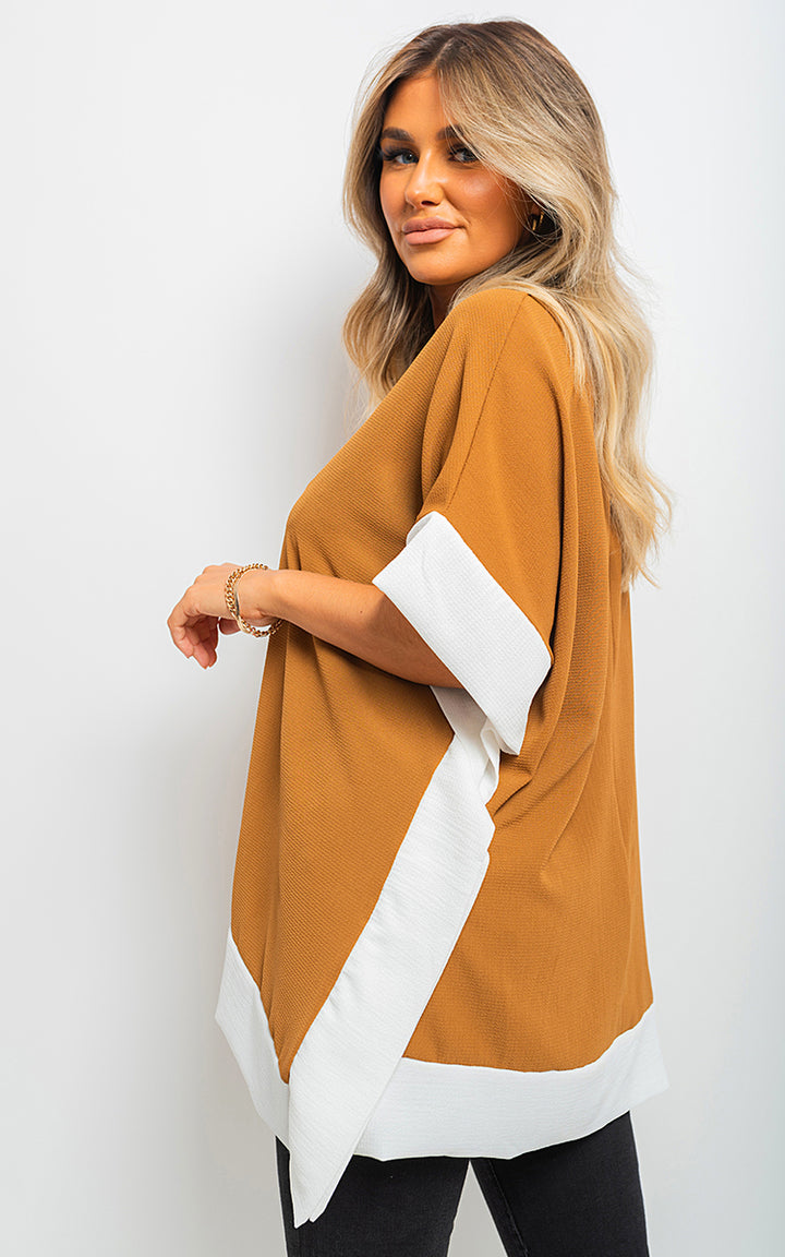 Woman wearing the Oversized Contrast Hem Flare Sleeve Top, showcasing its relaxed fit and fashionable flared sleeves. A stylish piece from Holiday Clothes UK.