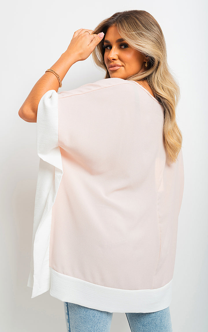 Woman wearing Oversized Contrast Hem Flare Sleeve Top, showcasing its relaxed fit and stylish flare sleeves in a casual setting.