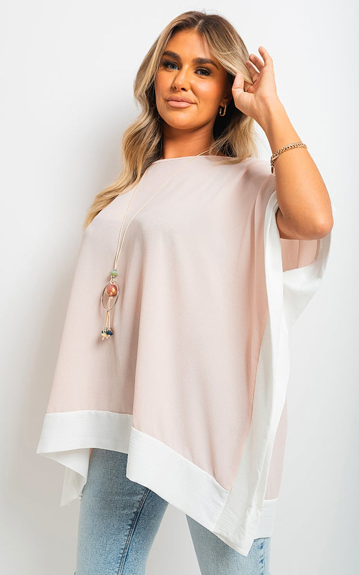 Woman wearing the Oversized Contrast Hem Flare Sleeve Top, showcasing its flared sleeves and relaxed fit, ideal for versatile, stylish holiday wear.