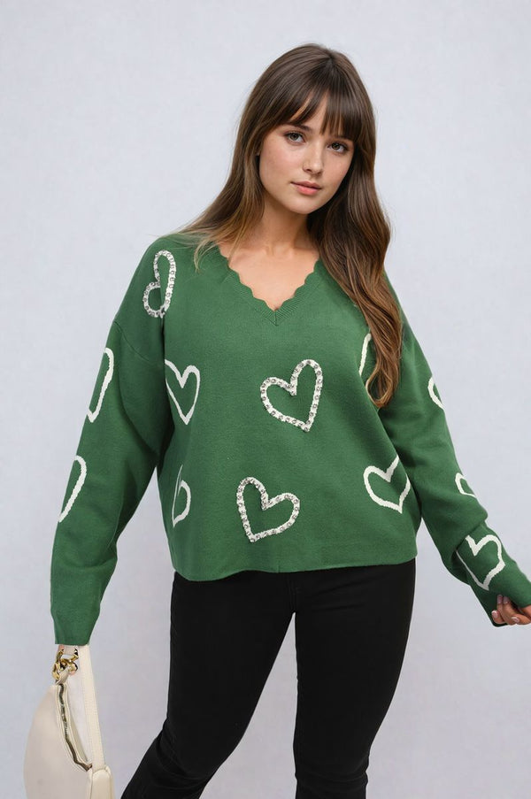 Woman wearing V-neck Embellished Hearts Long Sleeve Knitted Jumper, featuring white heart details, suitable for pairing with jeans or leggings for a cozy look.