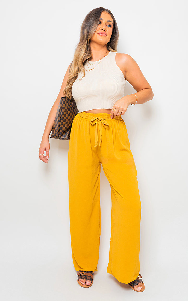 Drawstring Waist Wide Leg Trouser showcased by a woman wearing a white top, highlighting the flowy silhouette and adjustable waist for a chic, comfortable fit.