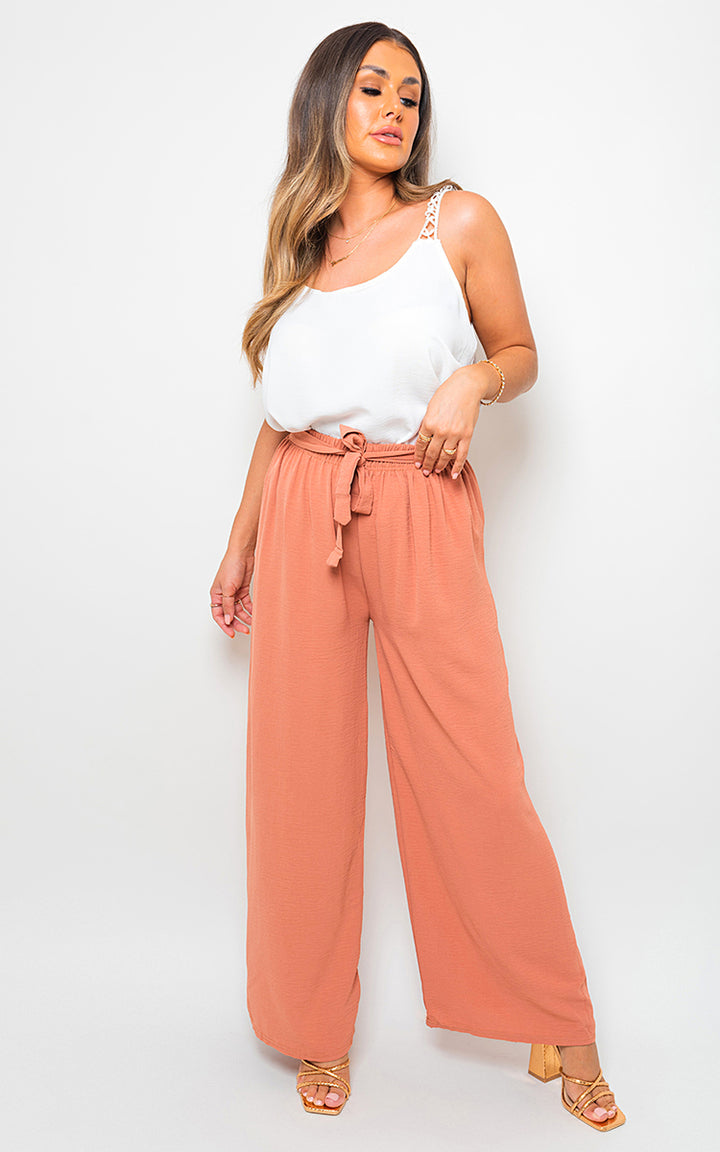 Woman wearing Lauryn Drawstring Waist Wide Leg Trousers, highlighting their wide-leg design and drawstring waist for a chic and comfortable fit.