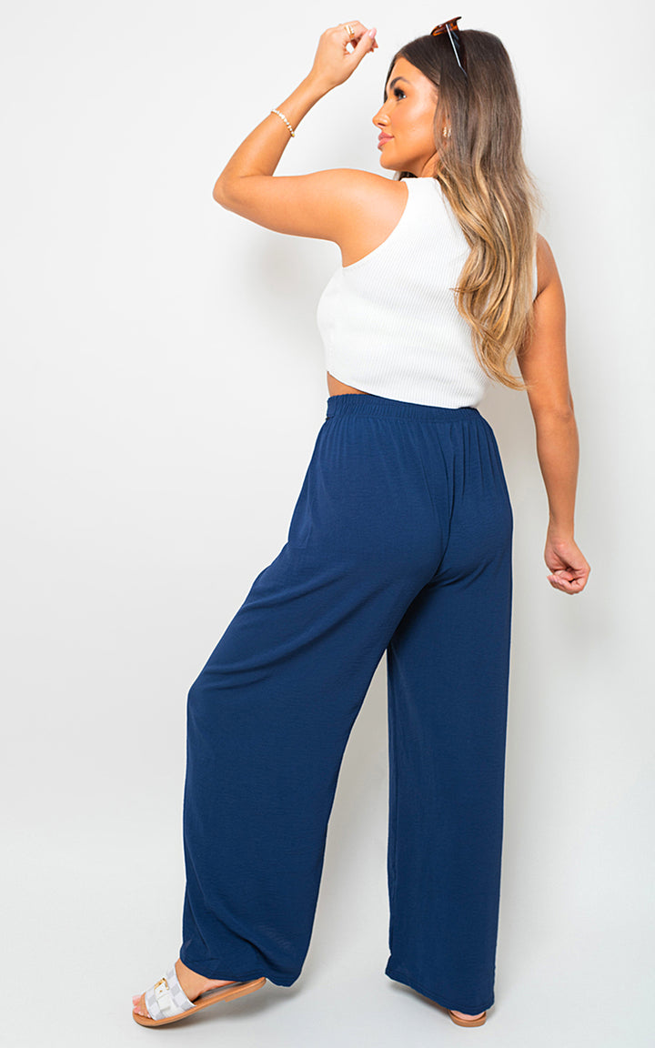 Woman wearing Lauryn Drawstring Waist Wide Leg Trousers, showcasing a chic and relaxed fit perfect for stylish holiday and everyday wear from Holiday Clothes UK.