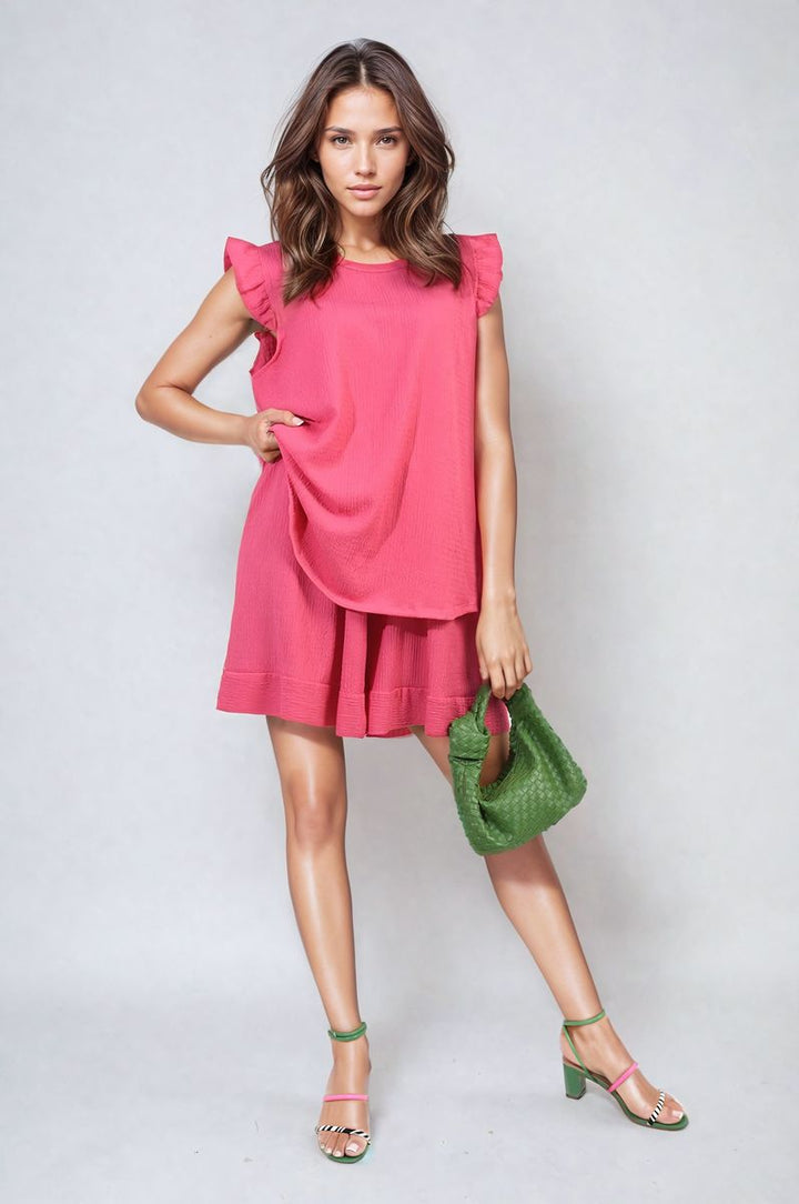 Woman in Ruffle Trim Sleeve Top and Shorts Co-ord Set, holding a green bag, embodies chic summer style from Holiday Clothes UK.