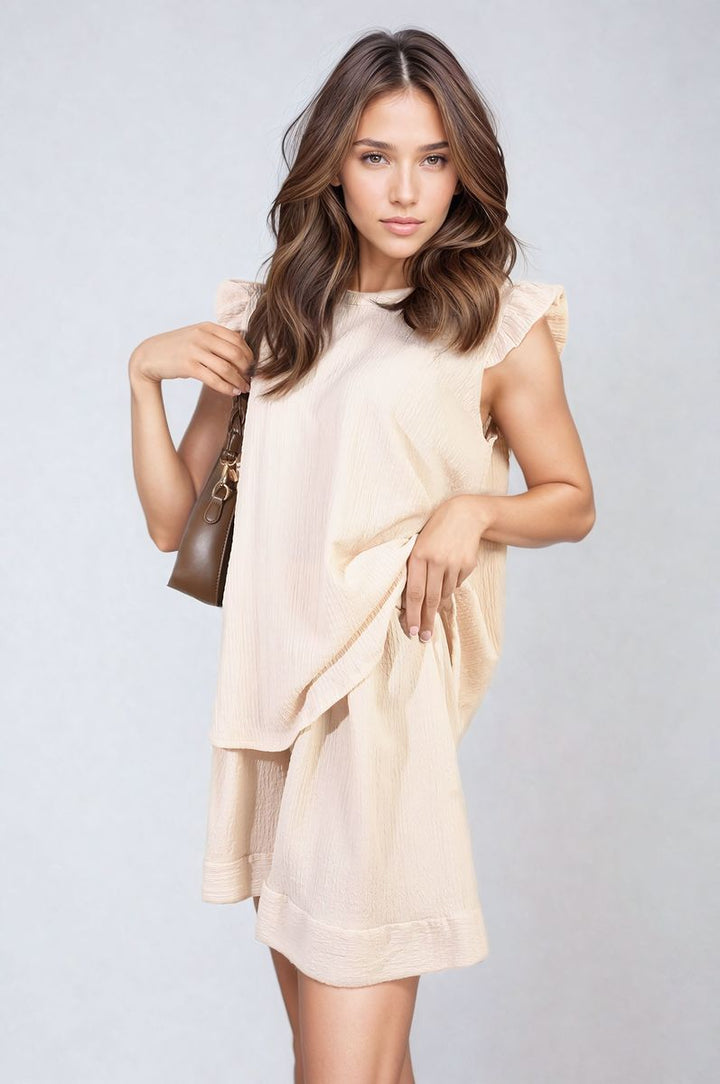 Woman modeling Ruffle Trim Sleeve Top and Shorts Co-ord Set, showcasing flirty ruffle sleeves and high-waisted shorts, embodying playful sophistication perfect for summer outings.