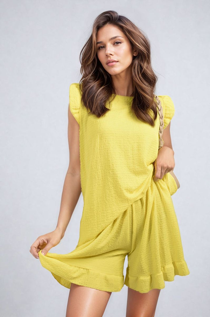 Woman in a Ruffle Trim Sleeve Top and Shorts Co-ord Set, showcasing playful elegance with ruffle sleeves and high-waisted shorts, perfect for summer outings.