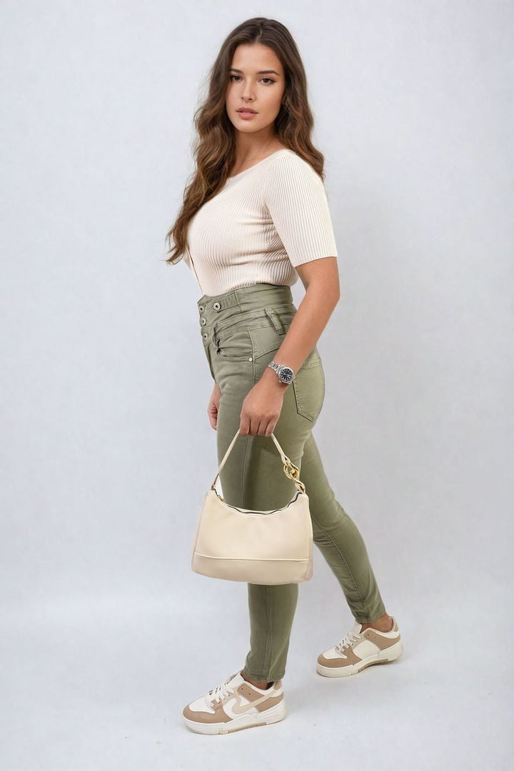 Woman showcasing High Waist Button Skinny Jeans with a white purse, highlighting the jeans' high-waist fit and stylish button-up front.