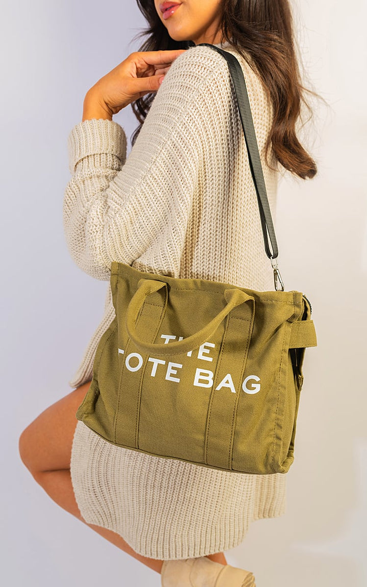 Woman holding Letter Pattern Canvas Shoulder Shopper Tote Bag, showcasing its spaciousness and stylish letter design, ideal for combining fashion and practicality.