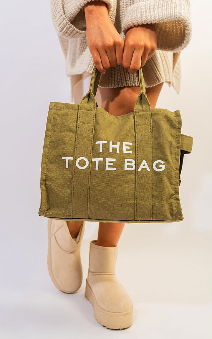 Person holding the Letter Pattern Canvas Shoulder Shopper Tote Bag, a stylish and practical accessory for everyday use, featuring a unique letter design.