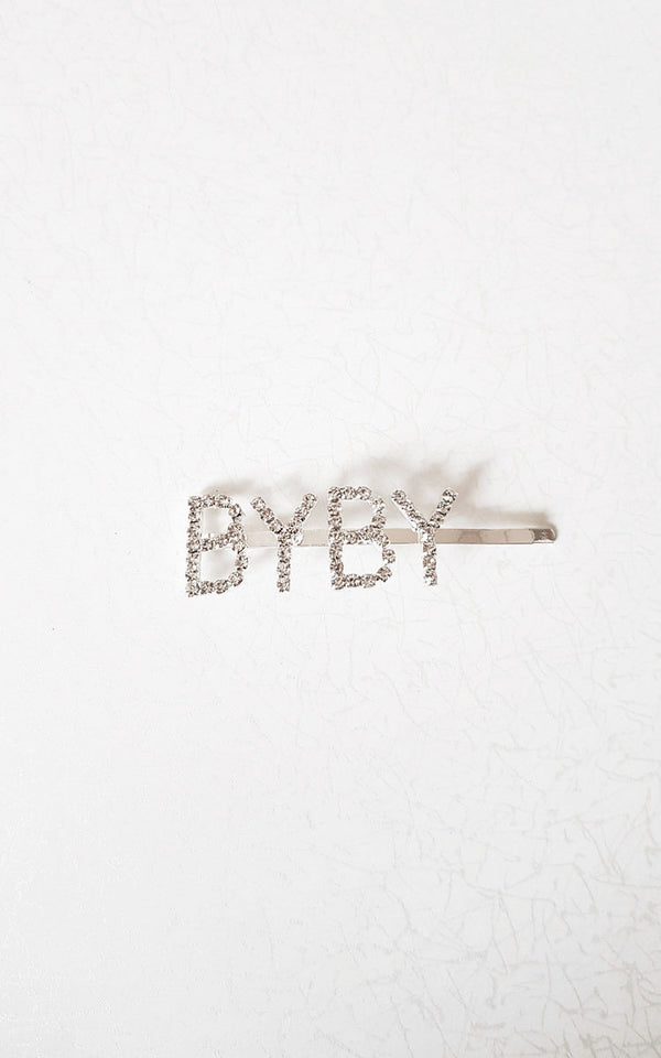 Slogan Diamante Detail Hair Clip with 'BYBY' letters on a silver-plated clip, ideal for adding a stylish touch to holiday outfits.