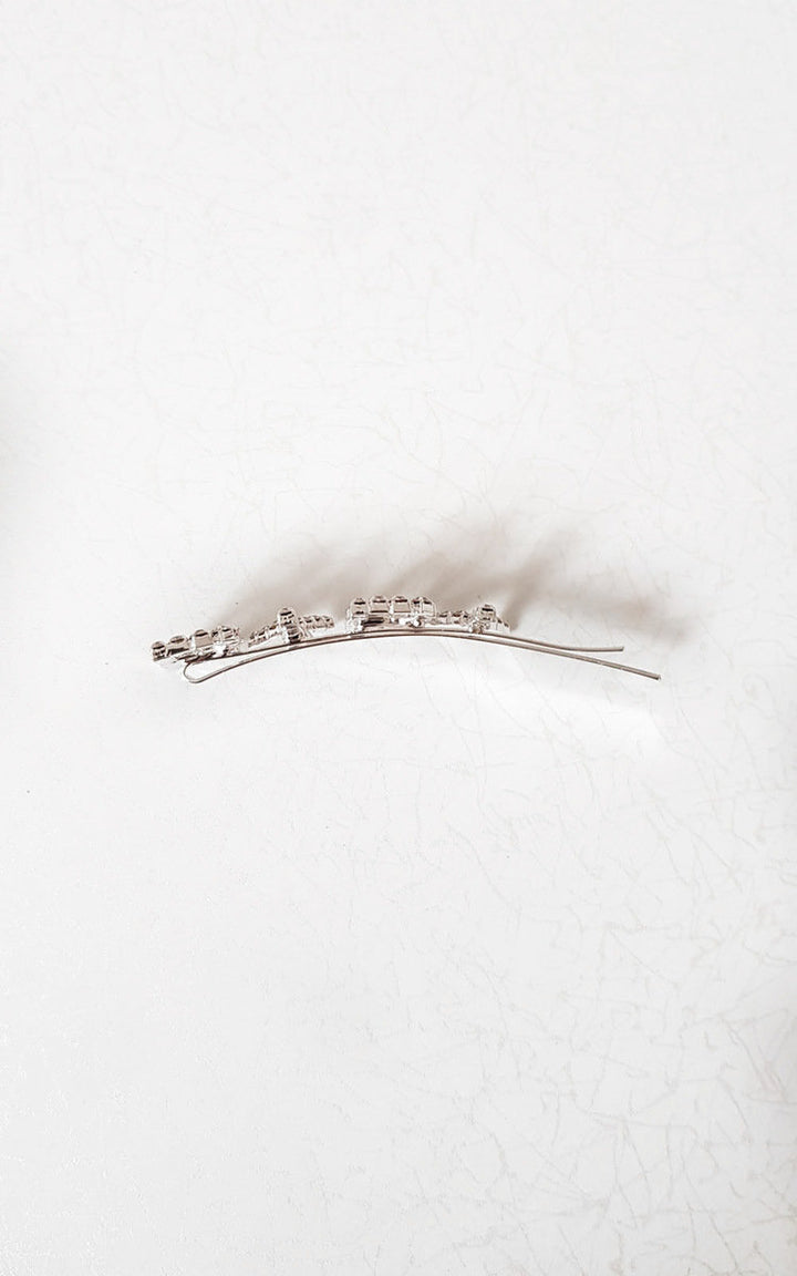 Slogan Diamante Detail Hair Clip: Silver-plated clip with 'BYBY' diamante design, showcased on a plain surface, perfect for stylish holiday or everyday accessorizing.