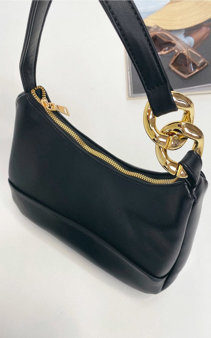 Handbag with Chain Detail: Black faux leather purse featuring a glamorous gold chain, perfect for storing essentials on a night out.