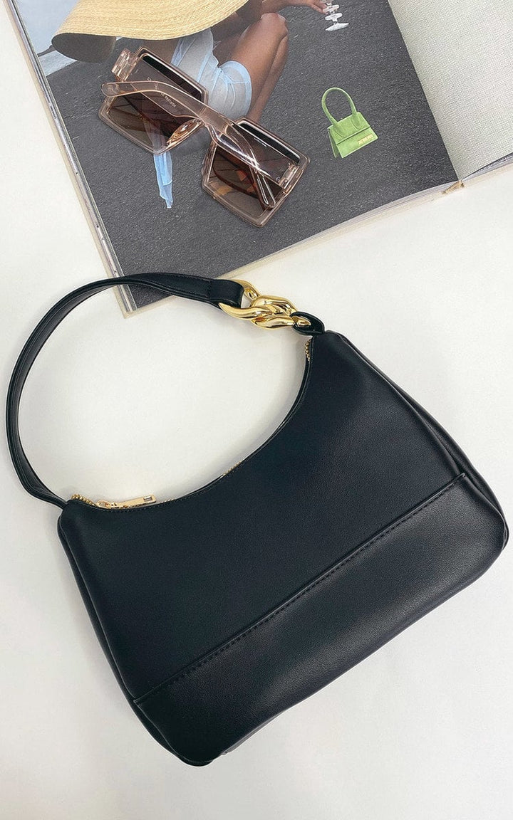 Handbag with Chain Detail: Black faux leather purse with gold chain, ideal for nights out. Timeless design for storing essentials.