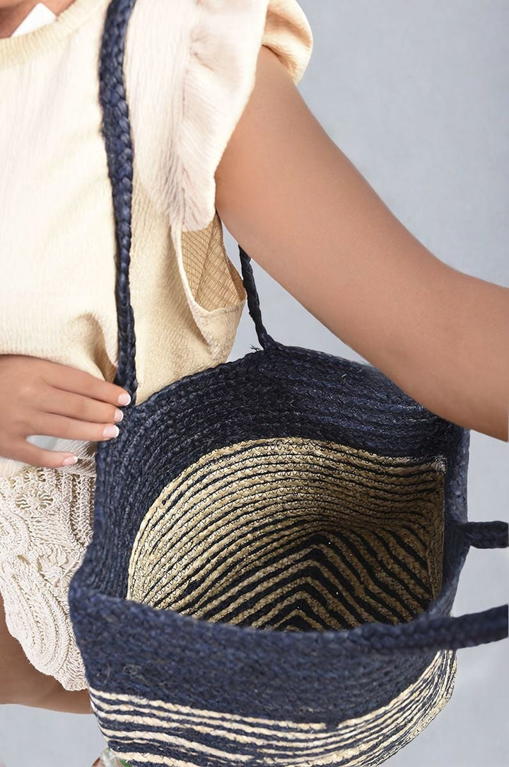 Woman holding Striped Beach Braided Tote Bag with braided handles, showcasing its spacious design, perfect for stylish holiday outings and everyday use.