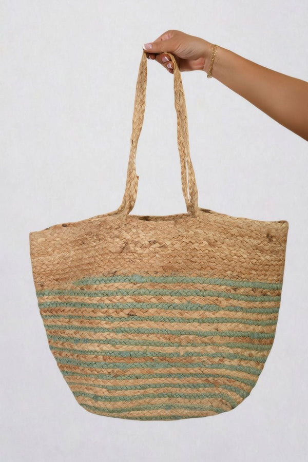 Hand holding a Striped Beach Braided Tote Bag with braided handles, perfect for beach outings and everyday use.