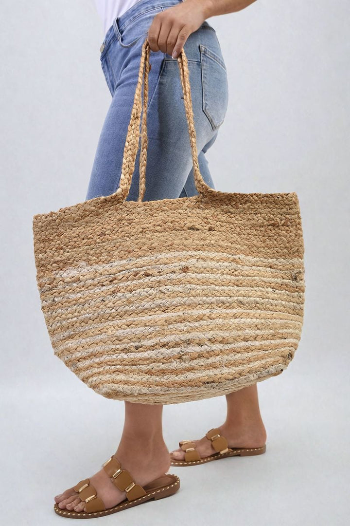 Person holding a Louisa Striped Beach Braided Tote Bag with braided handles and spacious interior, perfect for stylish beach outings and everyday use.