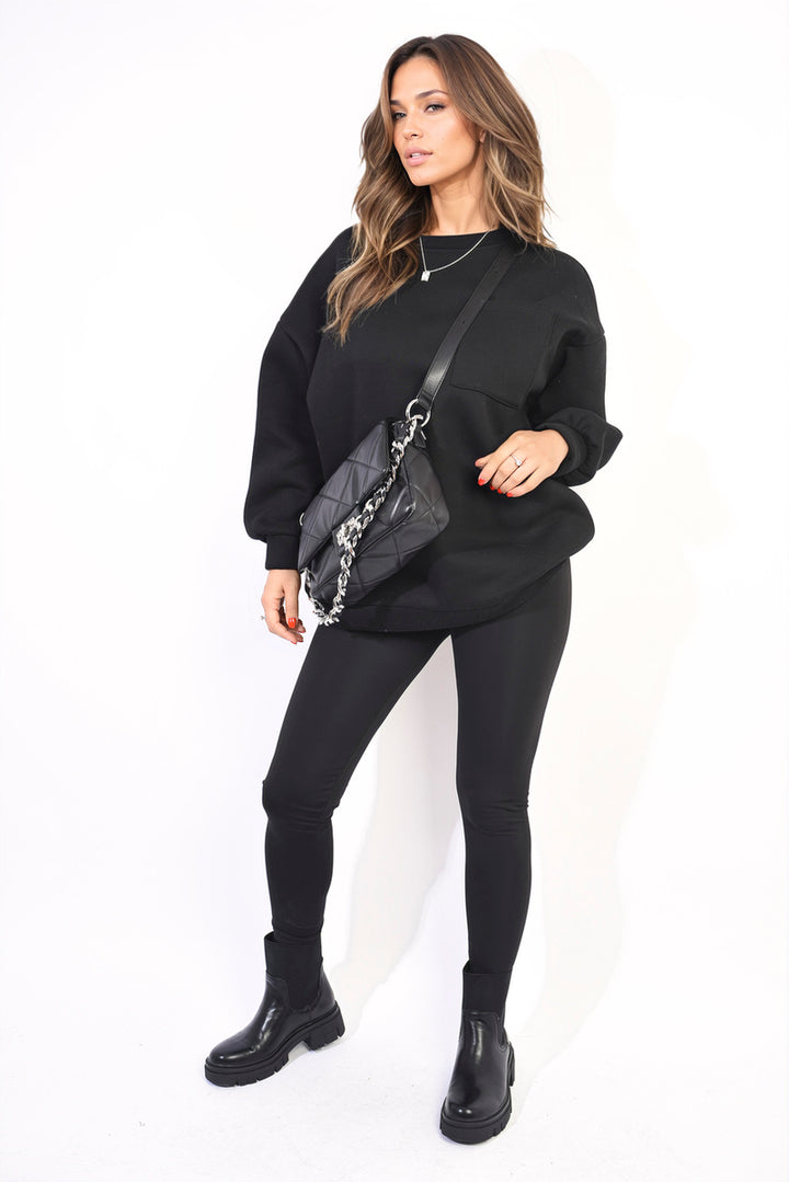 Lucy Oversized Pocket Sweatshirt and Leggings Co-ord Set, featuring an oversized sweatshirt and high-waist leggings, styled with black boots and a purse. Perfect for versatile comfort.