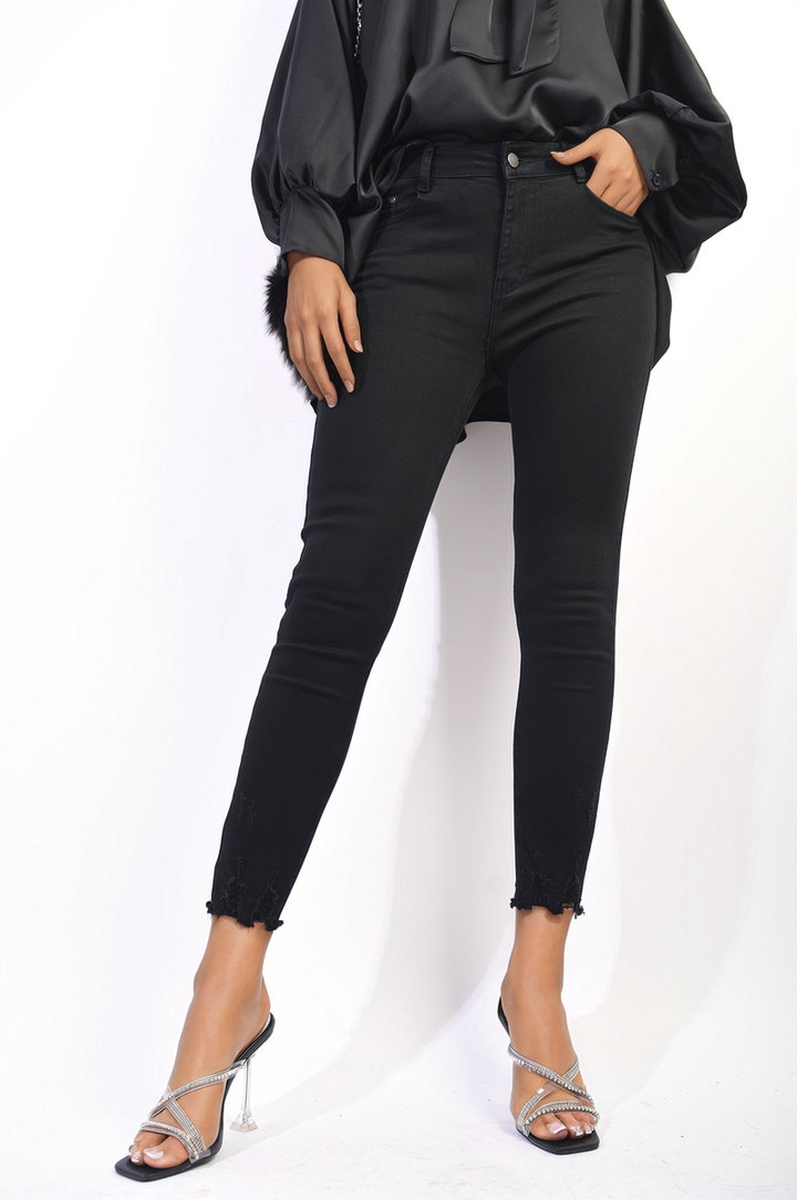 High Waist Distressed Hem Skinny Jeans featuring flattering fit and edgy detailing, perfect for versatile styling, worn by a woman with hands in pockets.