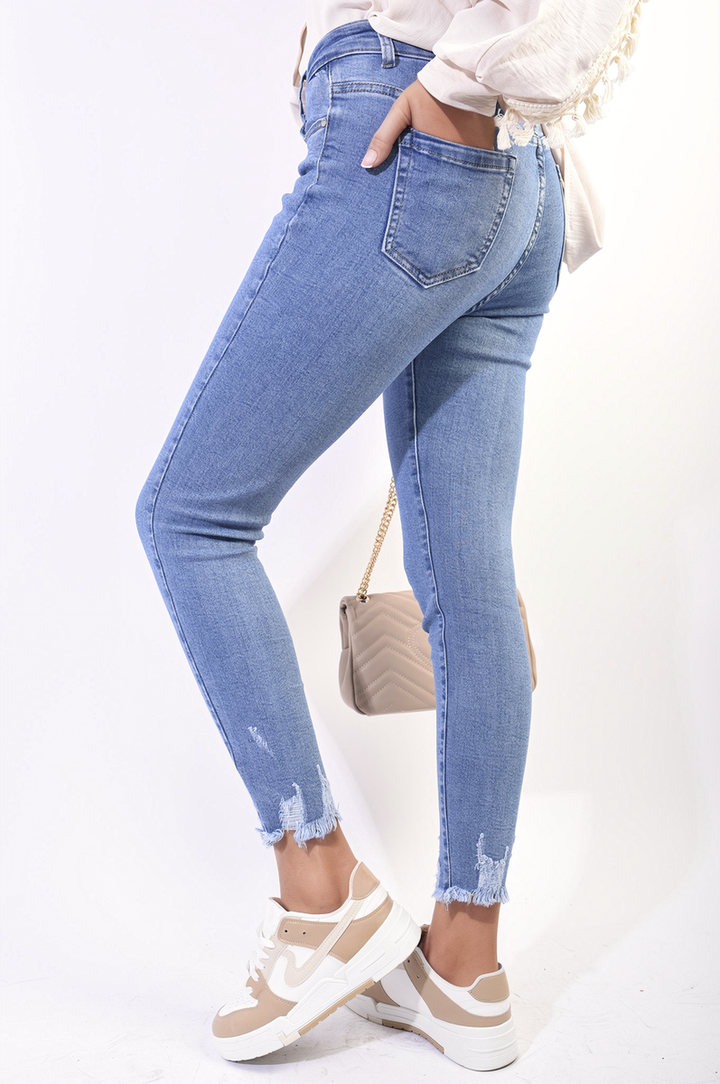 High Waist Distressed Hem Skinny Jeans worn by a woman, showcasing the flattering fit and edgy distressed hem detail, perfect for versatile styling.