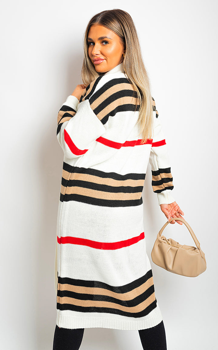 Woman in an oversized long striped knitted cardigan holding a tan purse, showcasing the cozy and stylish Luna Cardigan.