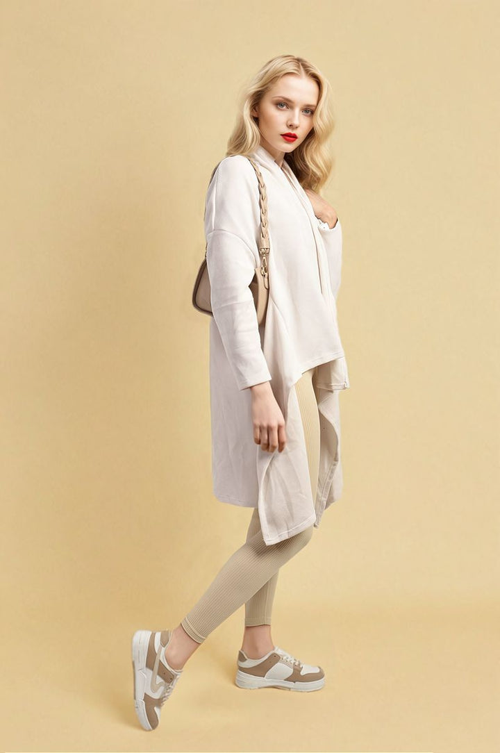 Woman wearing an Open Front Long Back Knitted Cardigan, posing stylishly. The cardigan's flowy design and cozy knit offer a chic, versatile look for any occasion.