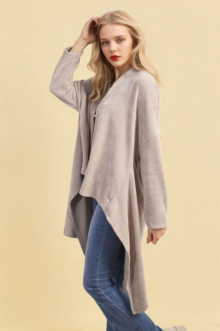 Woman modeling the Lydia Open Front Long Back Knitted Cardigan, showcasing its flowy, cozy knit design, ideal for versatile styling.