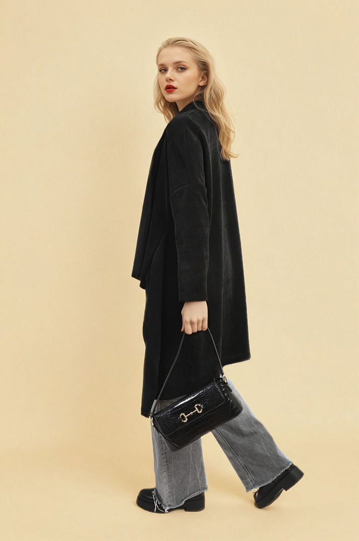 Woman wearing the Lydia Open Front Long Back Knitted Cardigan, showcasing its flowy design, paired with a black purse, highlighting a chic, versatile look.