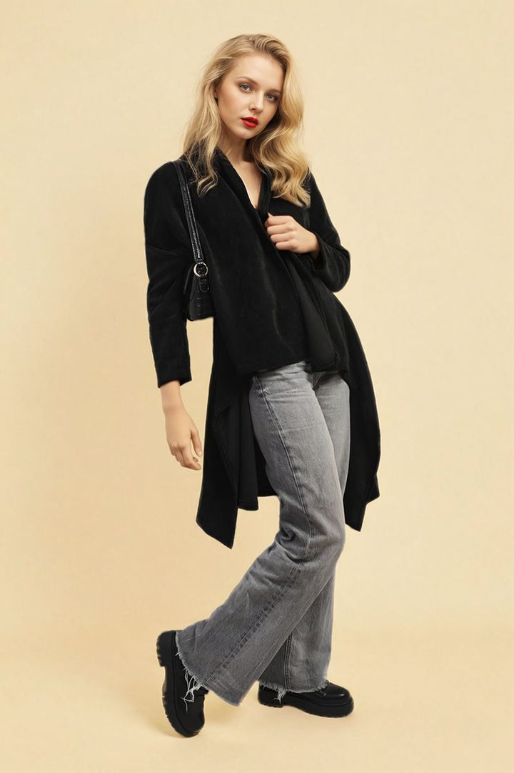 Woman wearing the Lydia Open Front Long Back Knitted Cardigan, styled effortlessly with distressed jeans and high heels, showcasing a chic and cozy look.