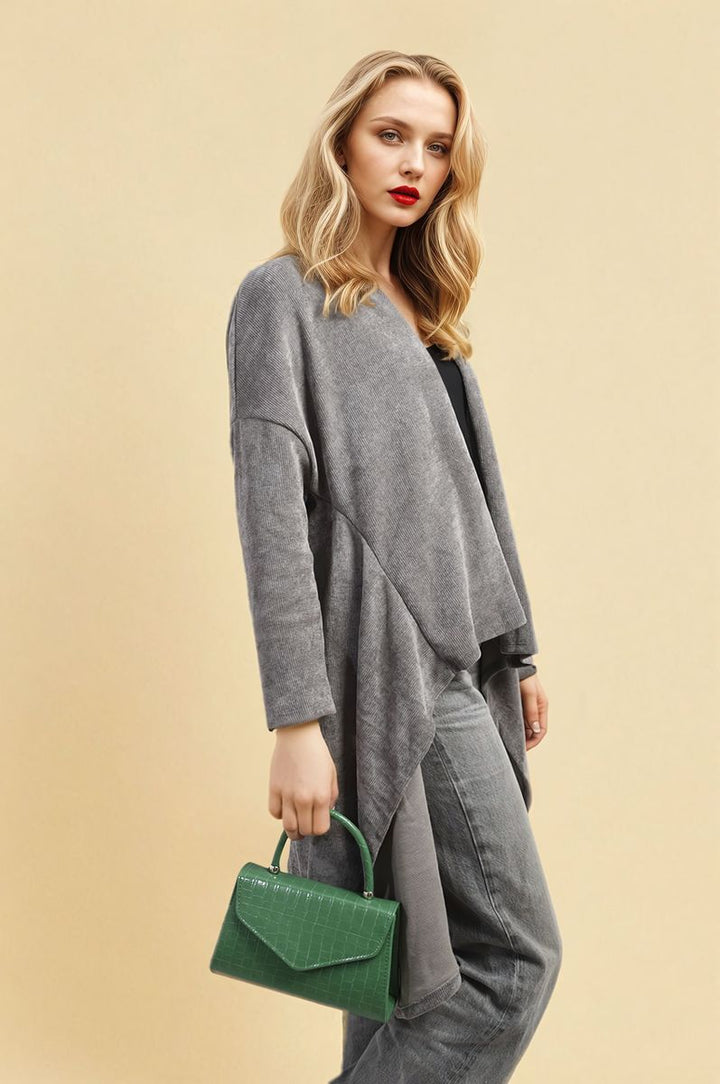 Woman in a grey sweater holding a green purse, showcasing the stylish Open Front Long Back Knitted Cardigan from Holiday-clothes.co.uk.