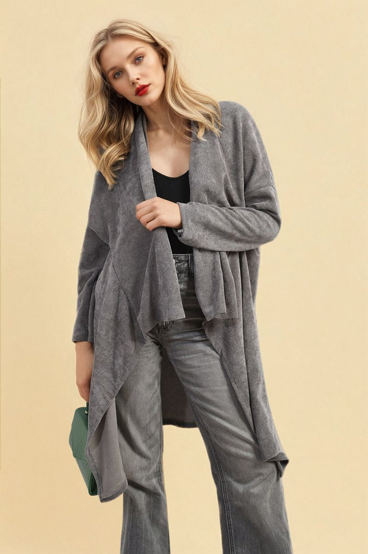 Woman wearing an Open Front Long Back Knitted Cardigan, posing confidently, highlighting the cardigan's flowy and cozy knit design, perfect for versatile styling.