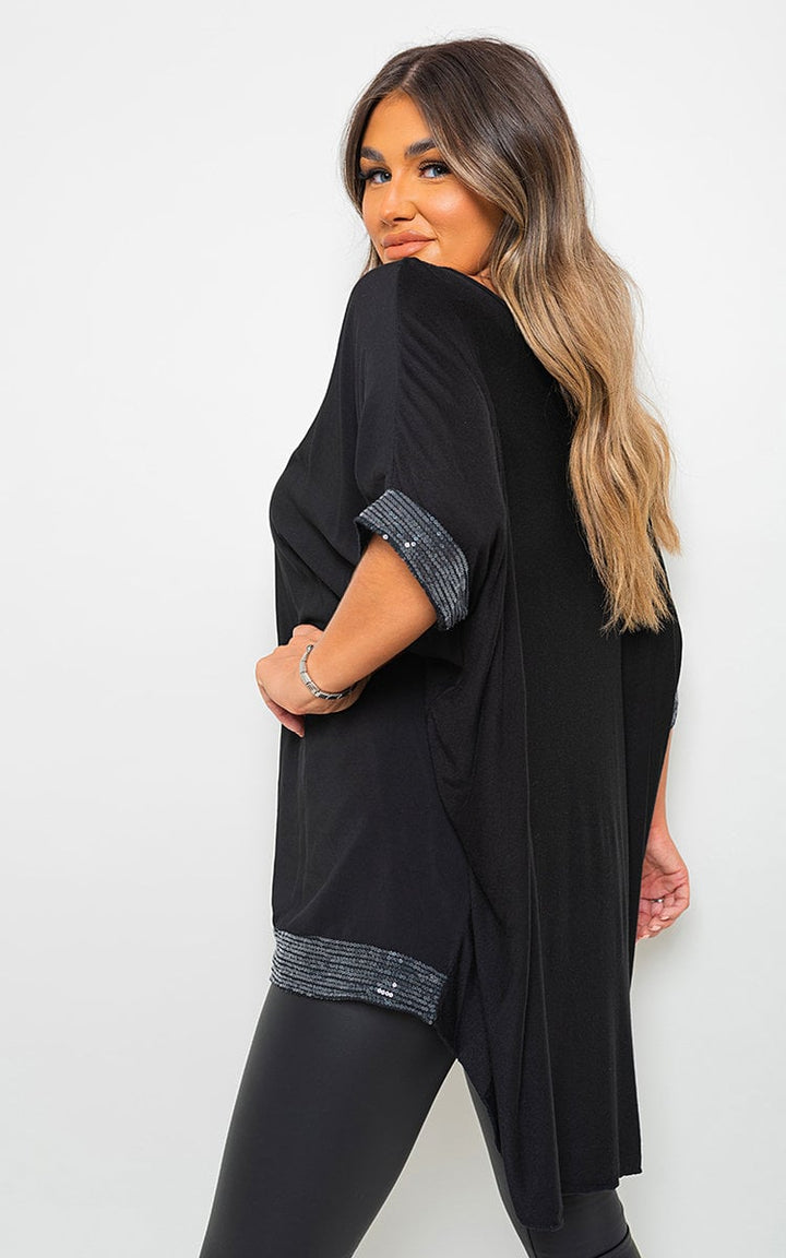 Woman wearing the Lydia Oversized Sequin Trim Top, showcasing its relaxed fit and dazzling sequin trim, perfect for versatile, stylish occasions.