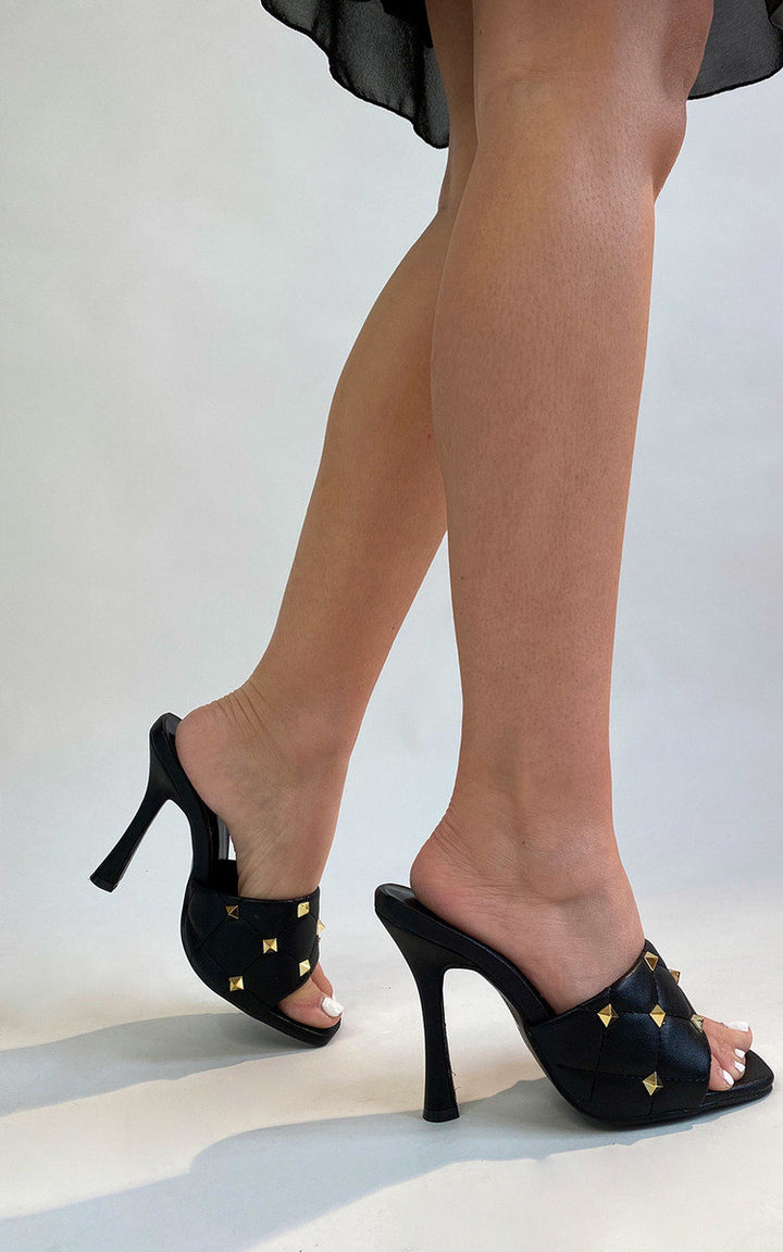 Studded High Heels from iKrush feature a sleek black design with gold spikes, perfect for making a stylish statement at any event.