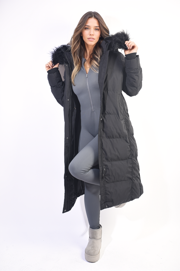 Woman wearing the Maisie Longline Faux Fur Hooded Puffer Jacket, showcasing its longline design and faux fur hood, ideal for stylish winter warmth.