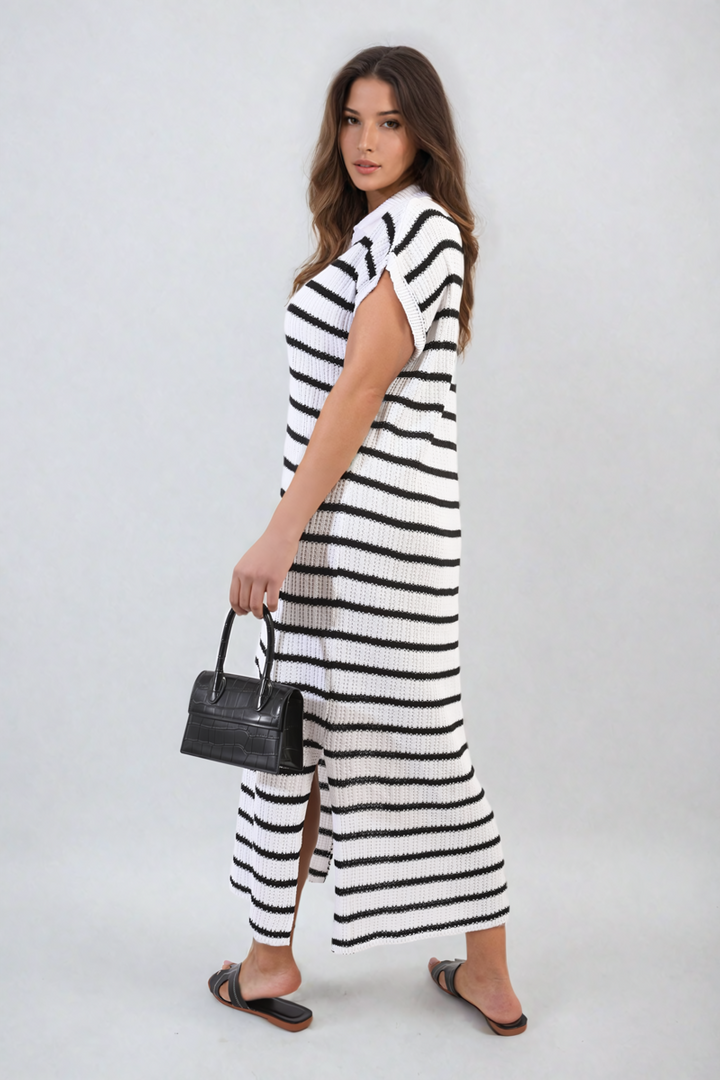 Woman wearing a Stripe Knitted V Neck Midi Dress, accessorized with a black purse and sandals, showcasing a chic and versatile fashion choice.