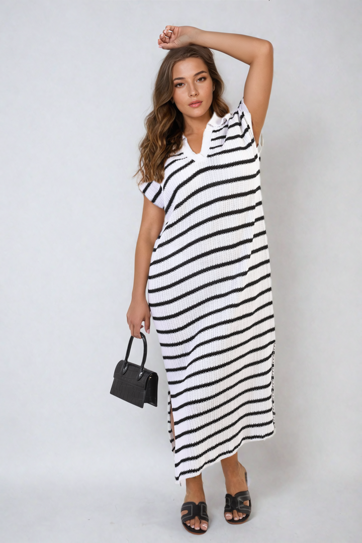 Woman in Stripe Knitted V Neck Midi Dress holding a black handbag, showcasing the dress's flattering fit and sophisticated V-neck design, perfect for versatile occasions.