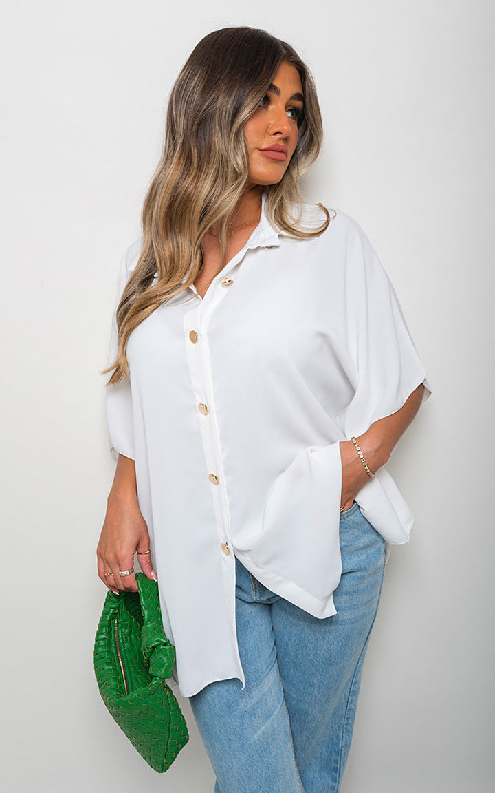 Woman wearing Margaret Button Down V Neck Casual Loose Top with a classic v-neckline and button closure, holding a green woven bag, showcasing casual style.