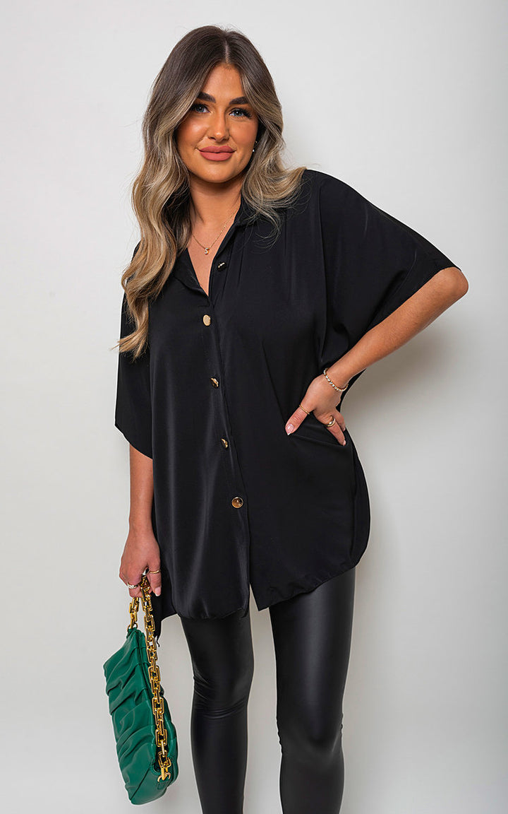 Woman wearing the Margaret Button Down V Neck Casual Loose Top, showcasing its elegant V-neckline and loose fit, paired with a fashionable green bag.