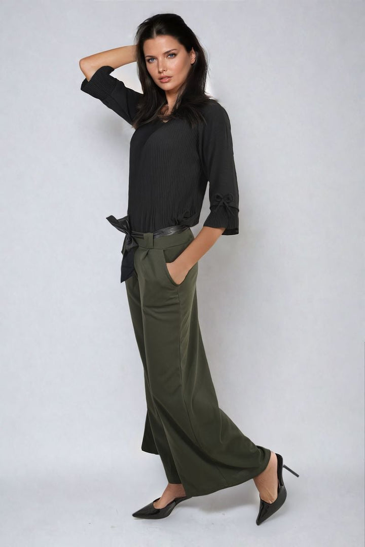 Woman wearing Belted High Waist Wide Leg Trouser, showcasing high waist and wide leg fit, with hands in pockets, styled for a chic, versatile look.