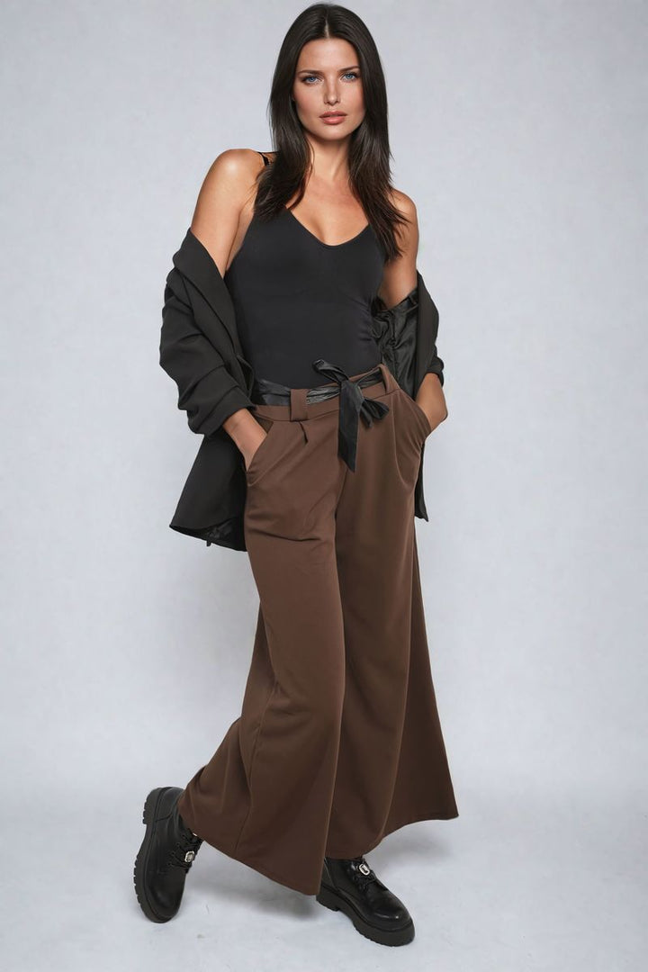 Woman modeling Belted High Waist Wide Leg Trouser, showcasing high waist and wide-leg fit, complemented by a waist tie for a chic, stylish look.