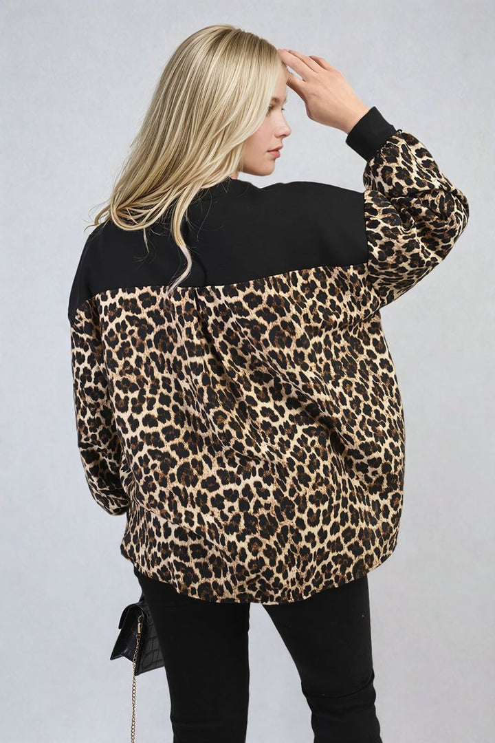 Woman wearing a Leopard Print Long Sleeve Knitted Jumper, featuring a bold pattern and cozy sleeves, perfect for stylish warmth.