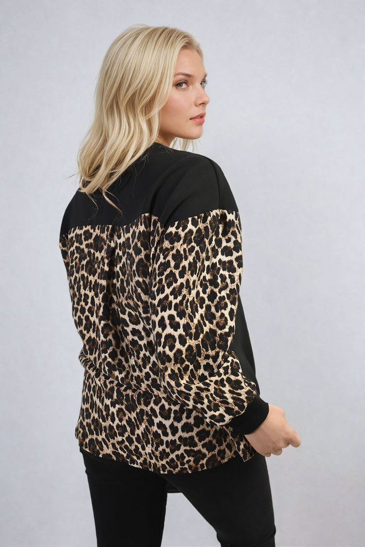 Woman wearing a Leopard Print Long Sleeve Knitted Jumper, showcasing its cozy design and trendy leopard pattern. Perfect for adding style to everyday wear.